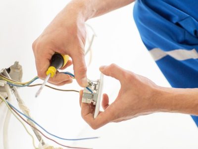 repair-renovation-electricity-people-concept-close-up-electrician-hands-with-screwdriver-fixing-socket-scaled